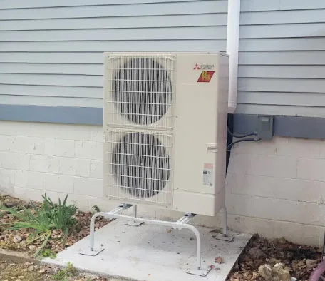 Mini-split outdoor condenser unit installed beside a Branson home
